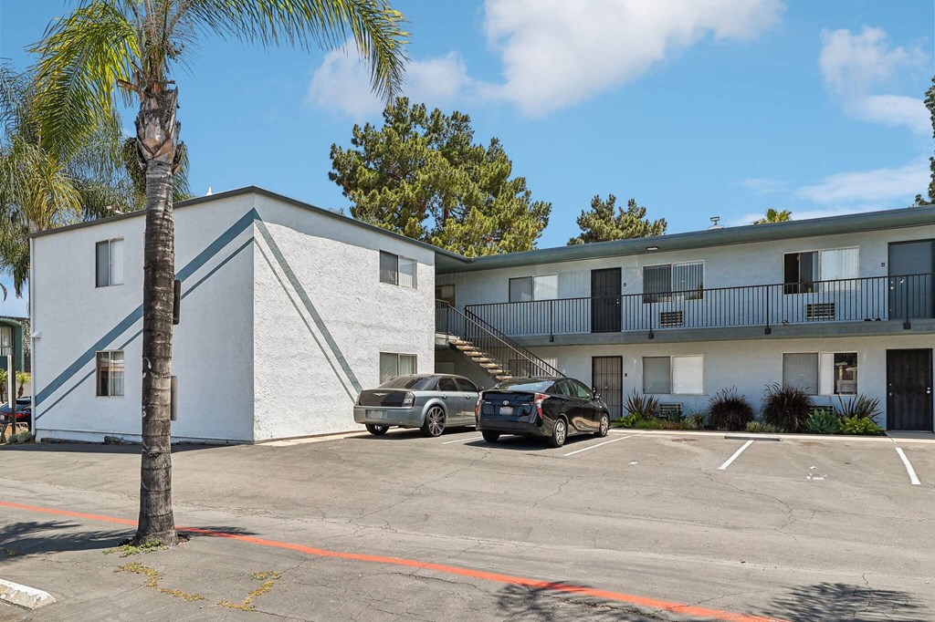 A parking lot with cars and a building in the background.