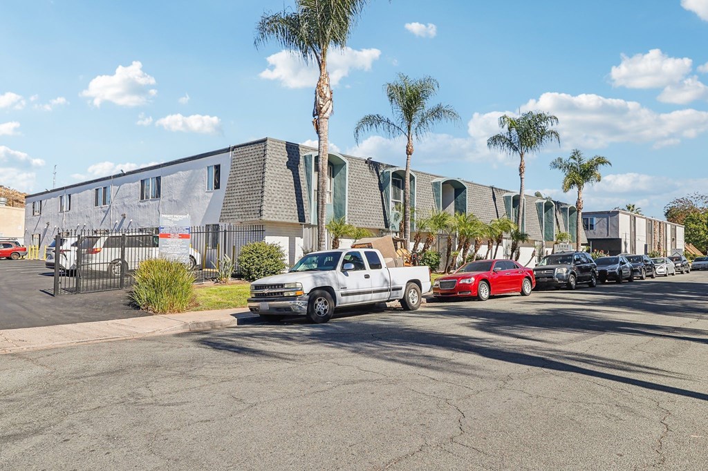 A parking lot with cars and a building in the background.