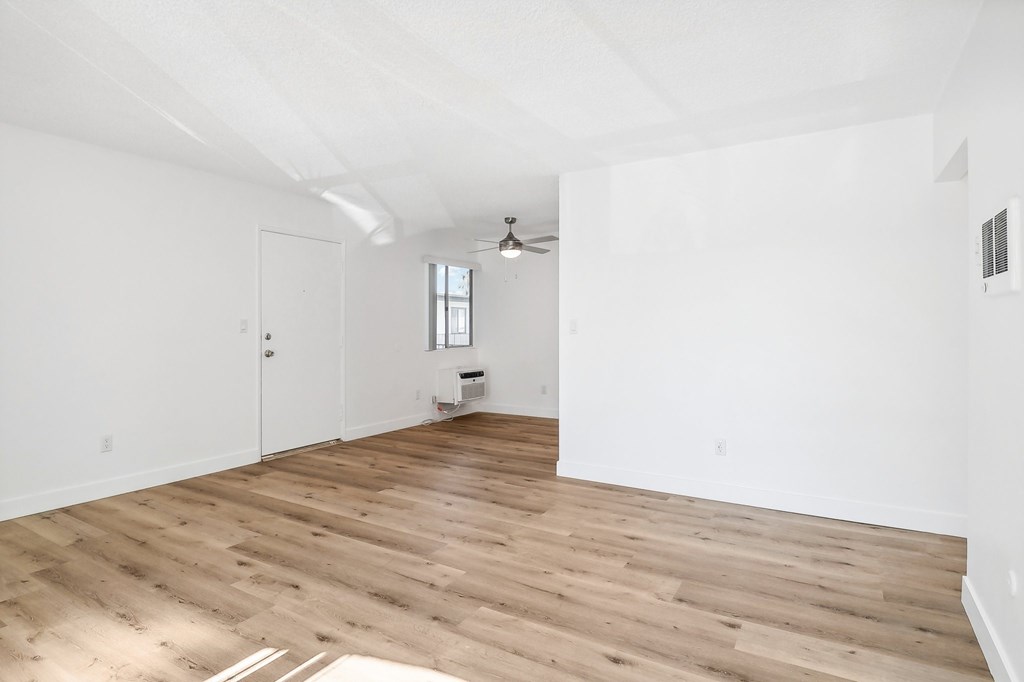 A room with wooden flooring and white walls.