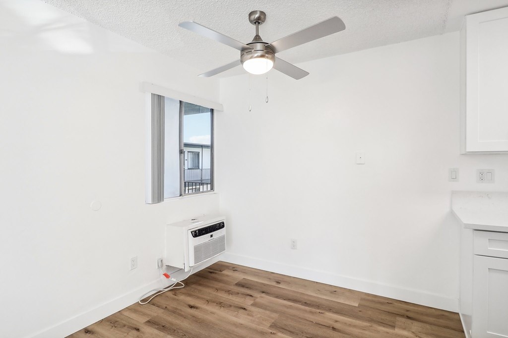 A room with a ceiling fan and a window.