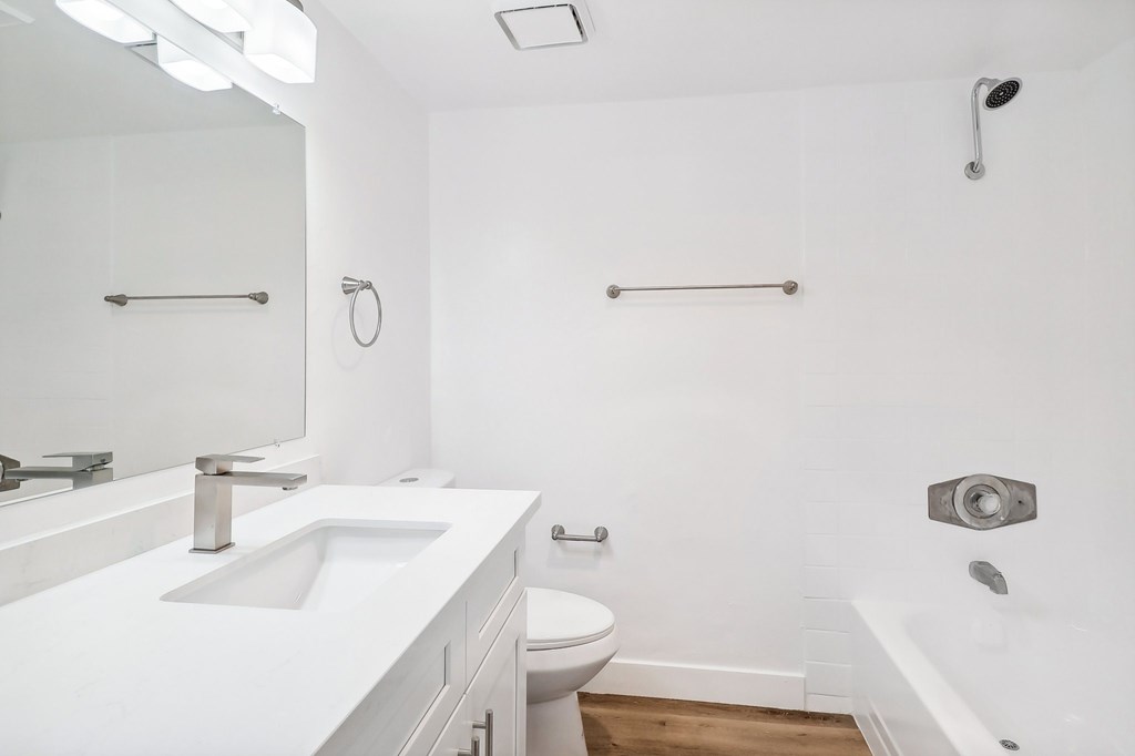 A white bathroom with a sink, toilet, and bathtub.