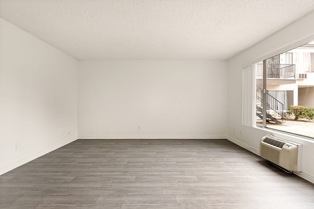 A room with a window and a balcony outside.