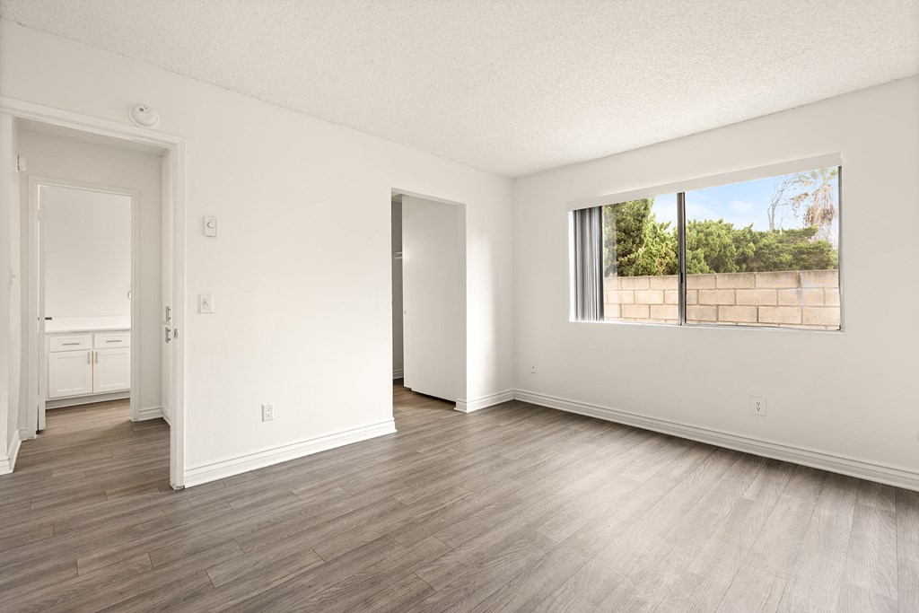 A room with a large window and wooden flooring.
