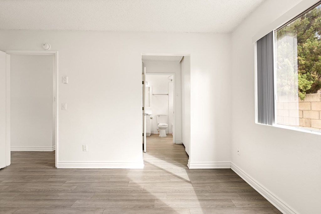 A white room with a doorway leading to another room.