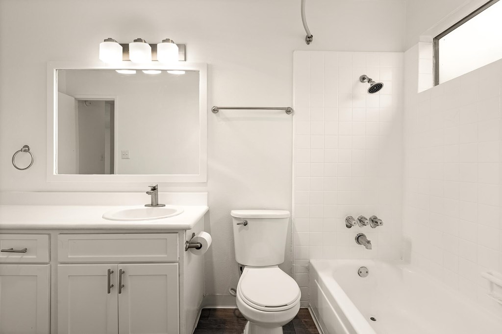 A white bathroom with a toilet, sink, and bathtub.