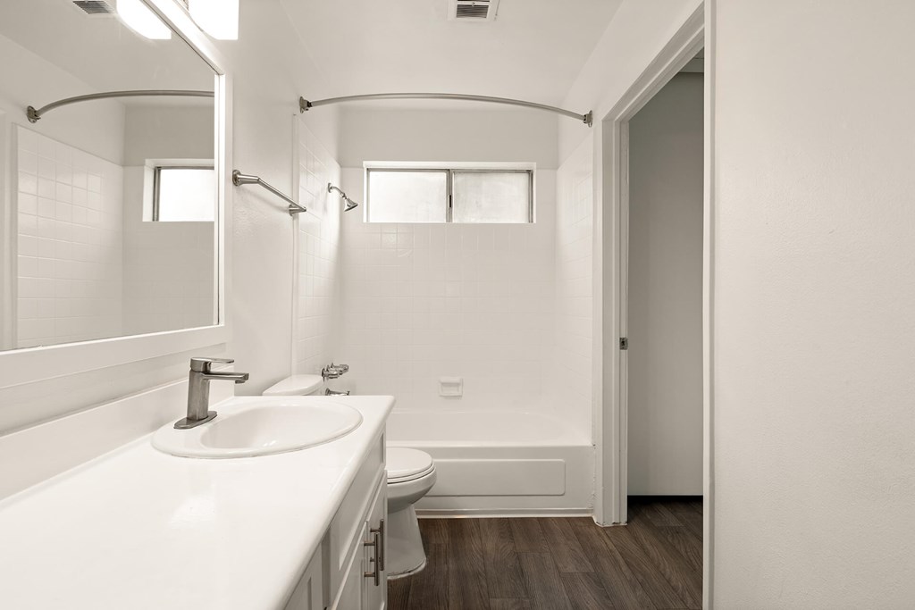 A white bathroom with a sink, toilet, and bathtub.