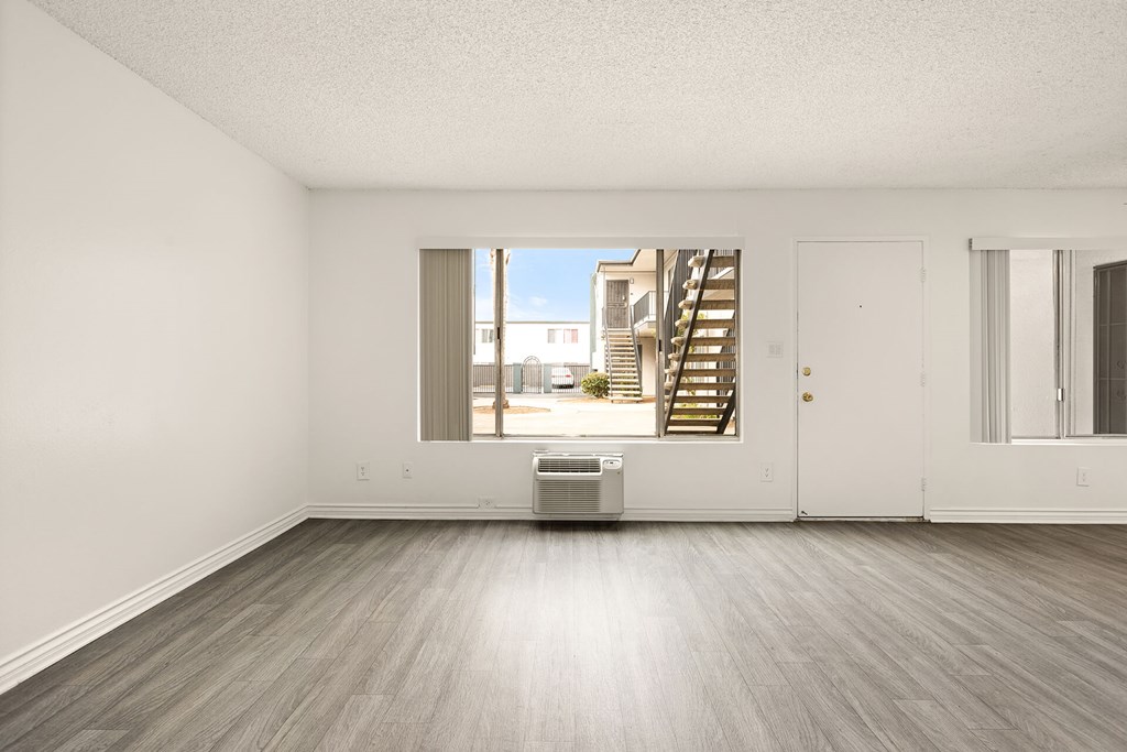 A large empty room with a staircase outside the window.