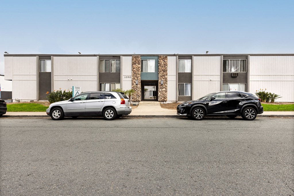 Two cars parked in front of a building.