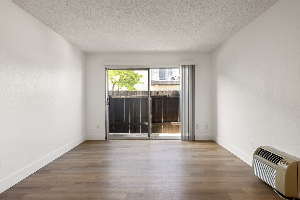 A room with a sliding door leading to a balcony.