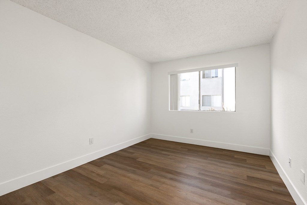 Empty room with wooden floor and a window.