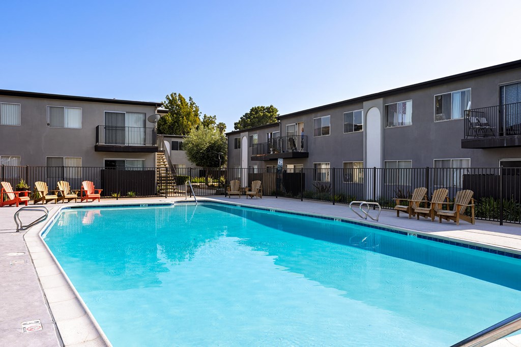 A swimming pool in front of apartment buildings.