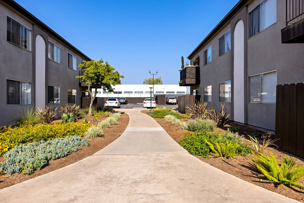 A concrete pathway leads between two rows of buildings.
