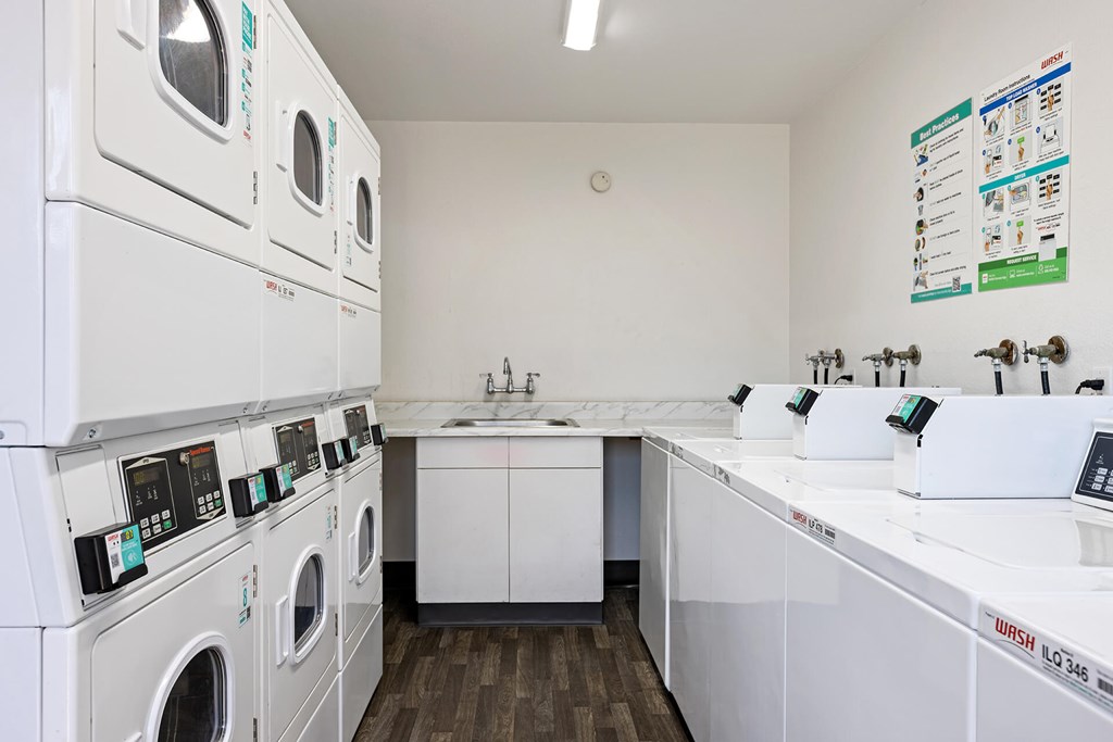 A laundromat with a row of washers and dryers.