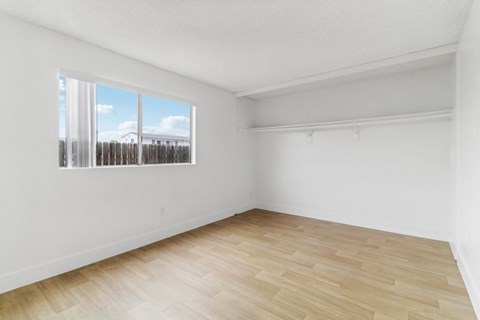 Empty room with wooden floor and a window.