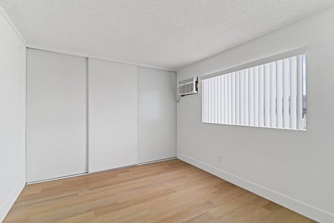 A room with a window and a wooden floor.