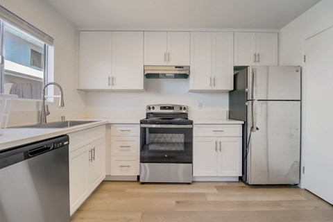 A kitchen with white cabinets and stainless steel appliances.