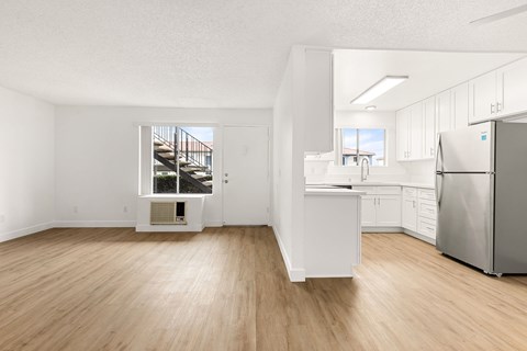 A kitchen with white cabinets and a stainless steel refrigerator.