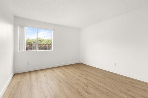 Empty room with a window overlooking a fence.