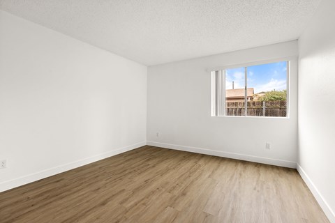 Empty room with wooden floor and a window.