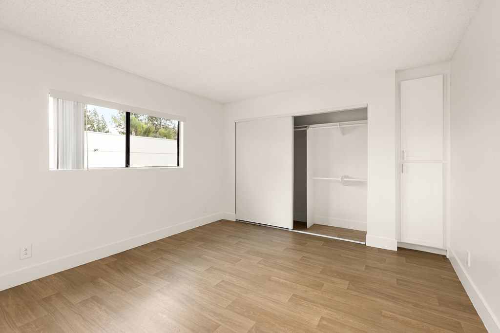 A room with wooden flooring and white walls.