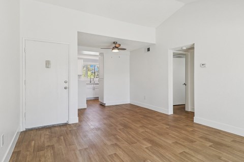 A room with a white door and a wooden floor.