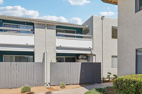 A modern building with a grey fence in front.