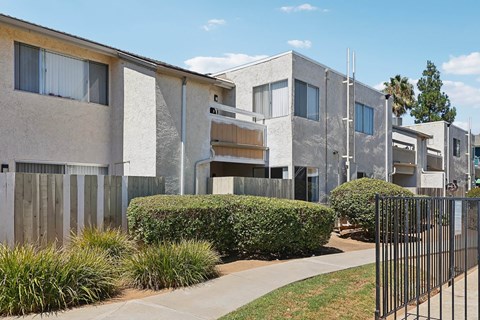 A row of modern houses with a black fence in front.