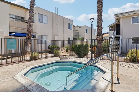 A small pool in a courtyard surrounded by buildings.