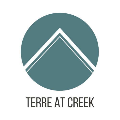 A logo with a mountain shape in the middle and the words "terre at creek" below it.