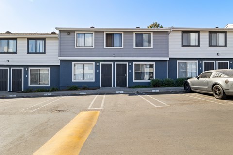 A car is parked in a parking lot in front of a building.