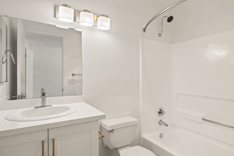 A white bathroom with a sink, toilet, and bathtub.