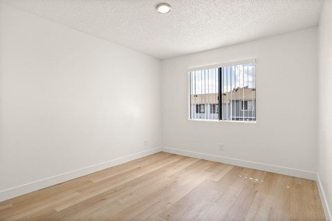 Empty room with wooden floor and a window.