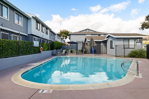 A swimming pool in a residential area with a sign that says