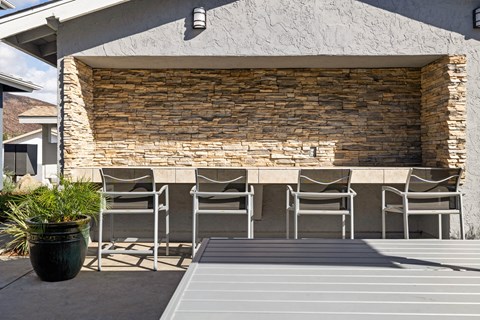 A patio with a table and chairs is set up outside a house.