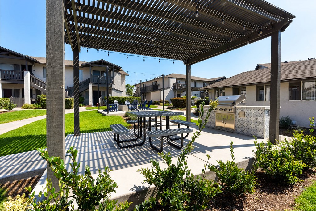 A patio with a table and chairs under a pergola.