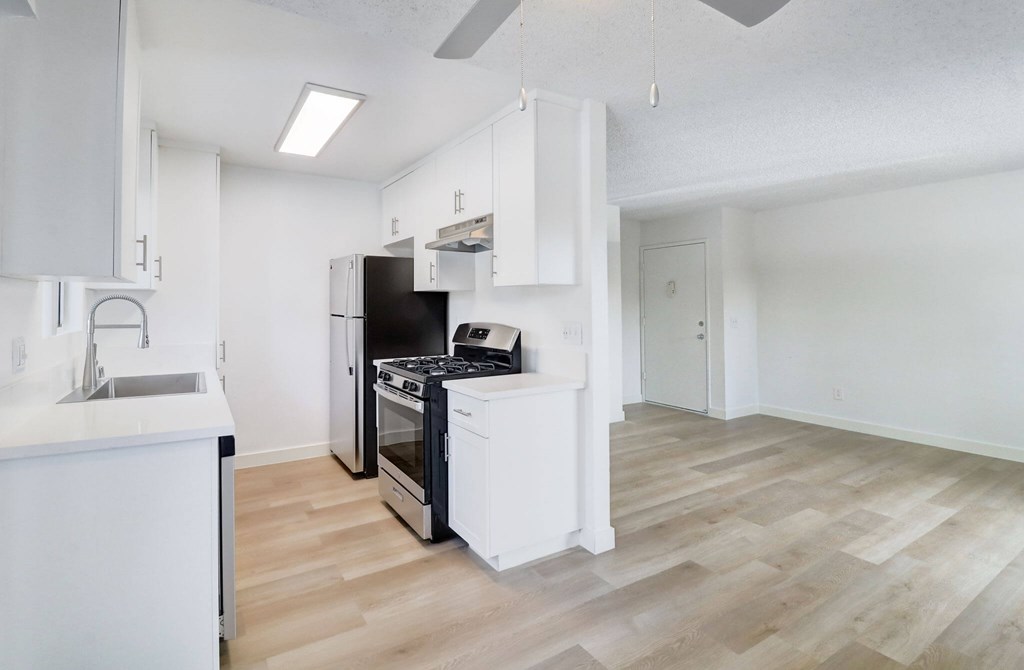 A kitchen with a black oven and white cabinets.