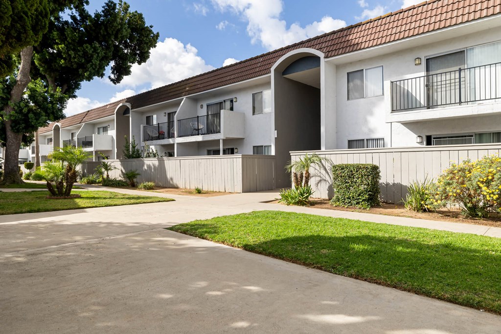 Apartment complex with a paved driveway in front.