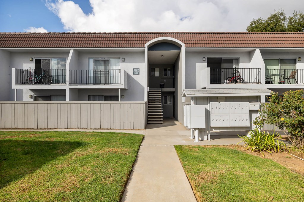 A building with a red roof and a balcony with a bicycle on it.