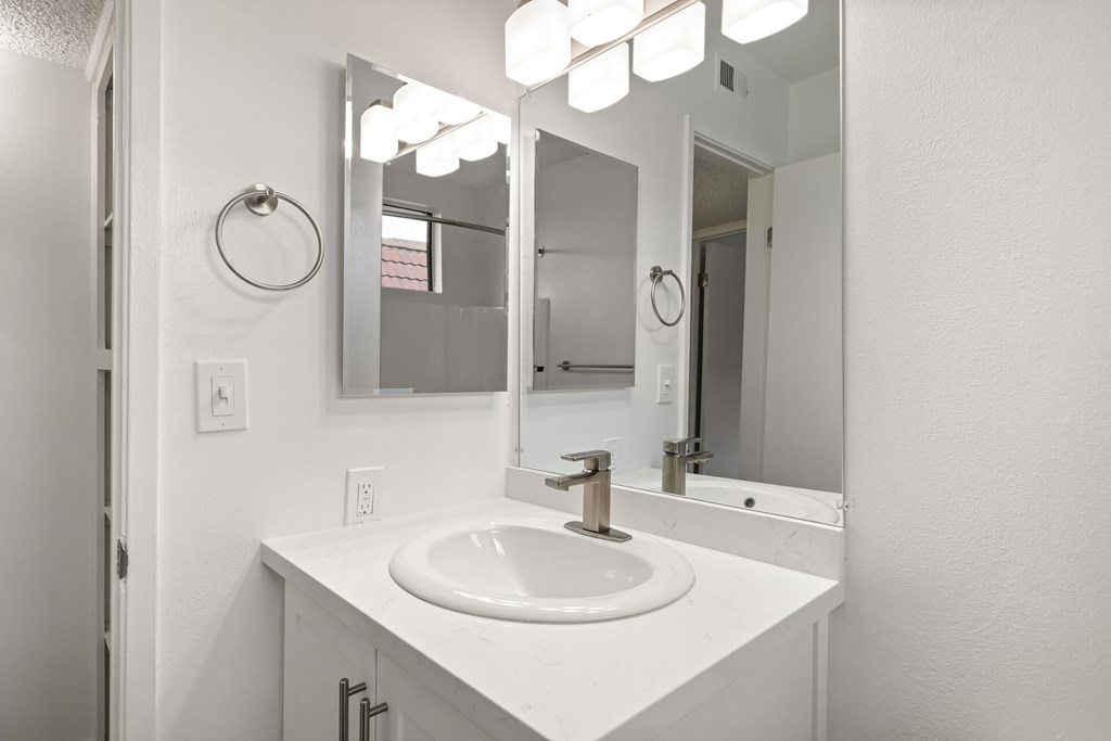A white bathroom sink with a mirror above it.