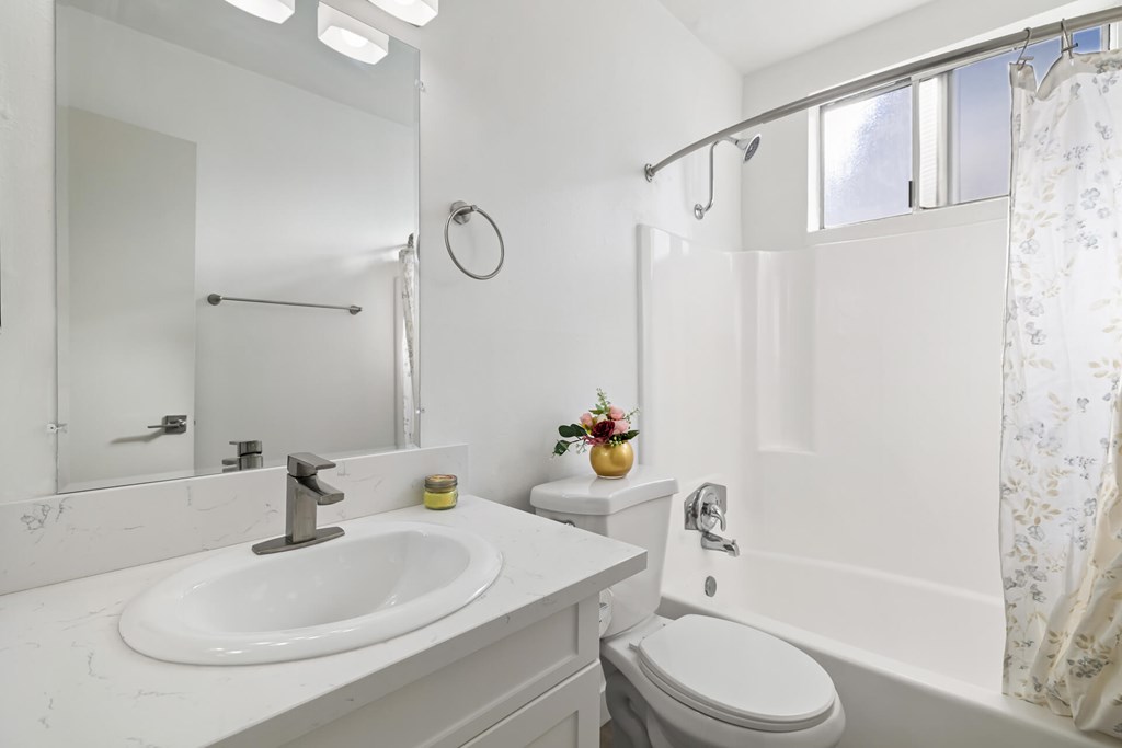 A white bathroom with a sink, toilet, and bathtub.