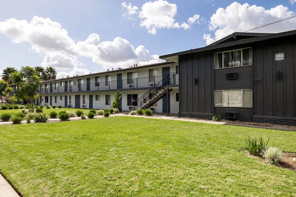 A row of houses with green lawns in front.