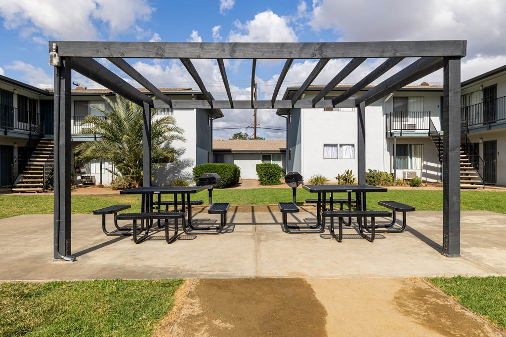 A patio with a table and chairs under a pergola.