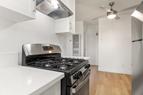 A modern kitchen with a stainless steel stove and white countertops.