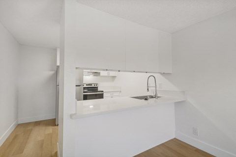 A kitchen with white cabinets and a sink.