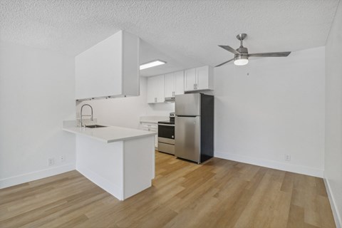 A kitchen with a white counter and stainless steel appliances.