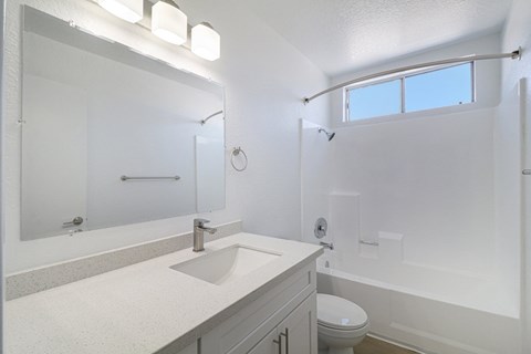 A white bathroom with a sink, toilet, and bathtub.