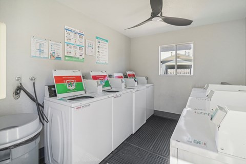 A row of washing machines are lined up in a laundromat.