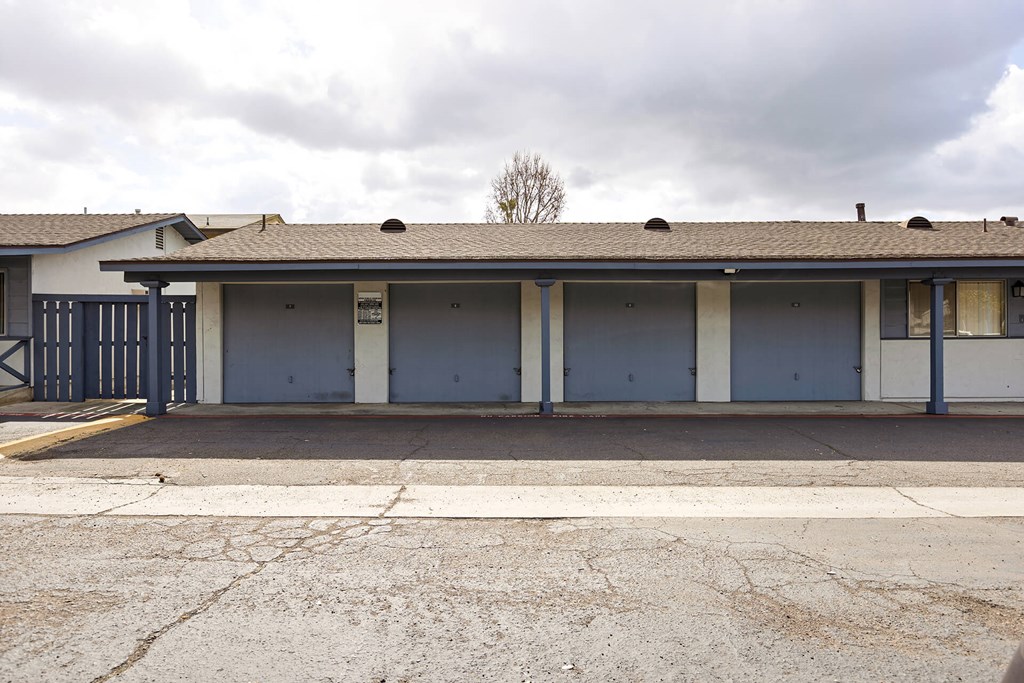 A building with a white and blue exterior and a tree in the background.