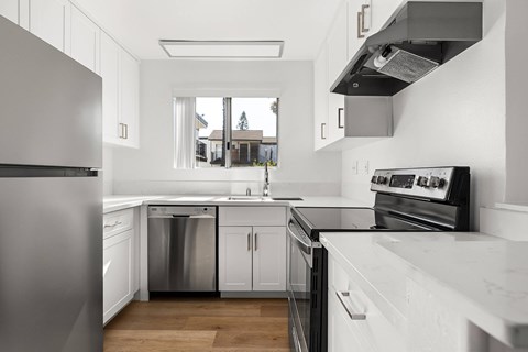 A modern kitchen with white cabinets and stainless steel appliances.