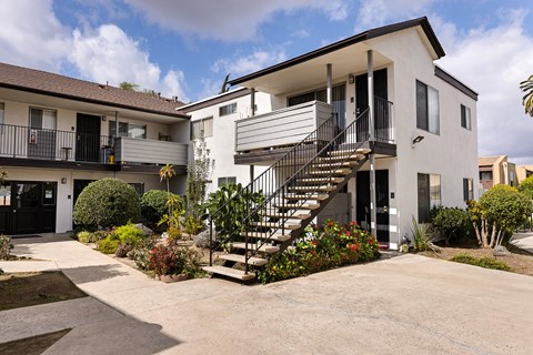 A modern two-story house with a balcony and a staircase.